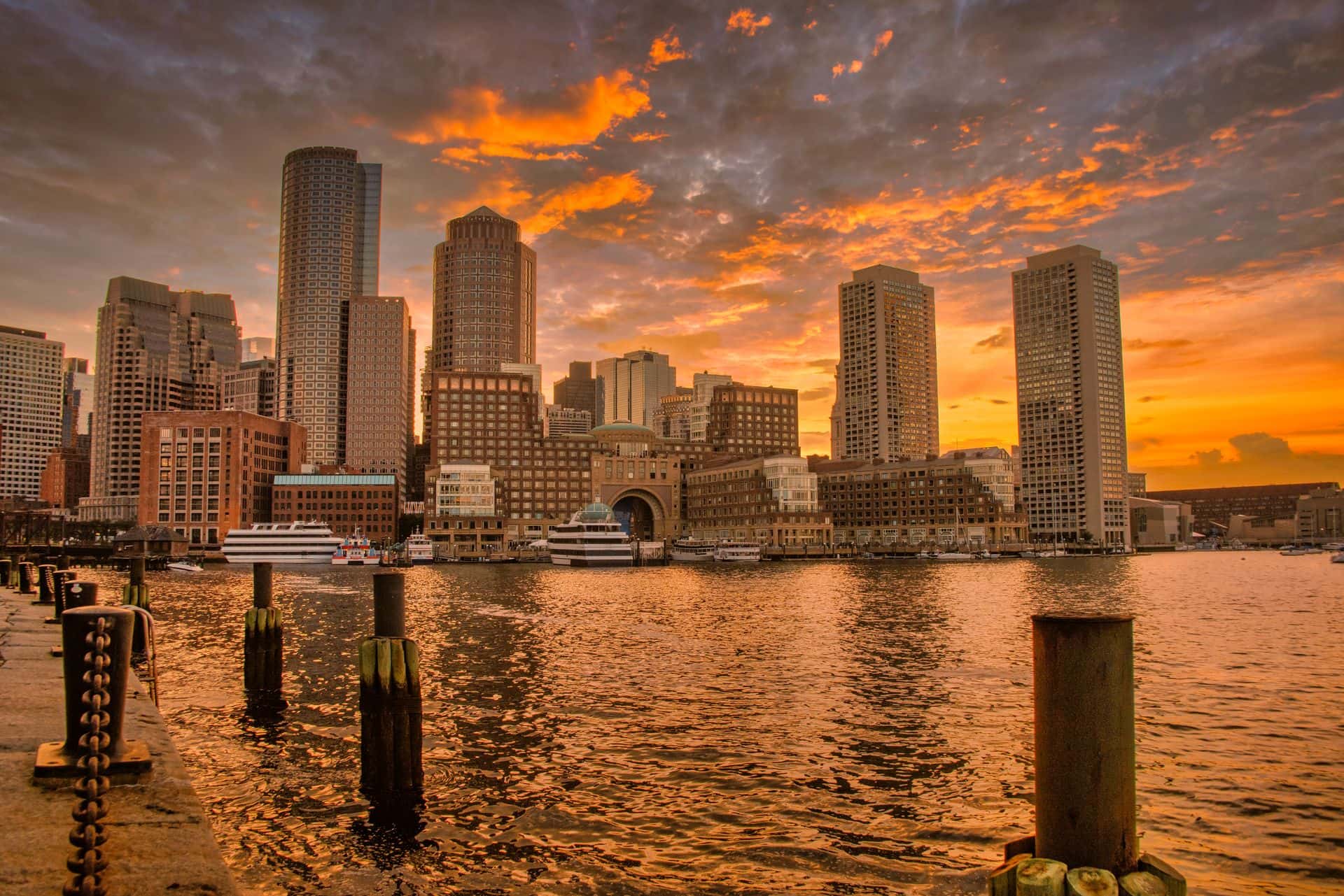 Boston Harbor and the downtown skyline at sunset, marking the federal court order postponing the rule that would end duration of status